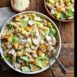 The Ultimate Chicken Caesar Pasta Salad Guide for Any Occasion 7 A bowl of creamy chicken caesar pasta salad with rotini pasta, romaine lettuce, grilled chicken, croutons, and shaved Parmesan on a wooden table
