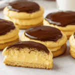 Boston Cream Pie Cookies filled with creamy vanilla pastry cream and topped with glossy chocolate ganache, with one cookie cut open. Image 2 – Ingredients and Cookie Dough