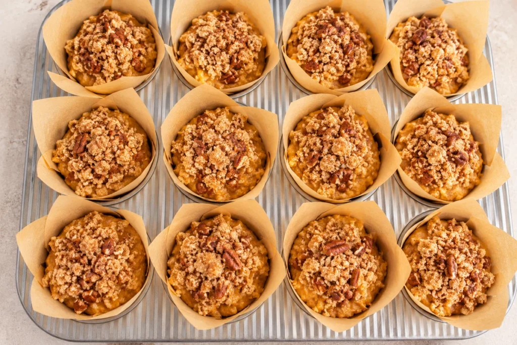Pumpkin Streusel Muffins with Pecan Topping (Moist, Fluffy & Easy Recipe) 7 Twelve pumpkin streusel muffins with pecan topping in parchment-lined muffin cups, ready to bake with a crunchy cinnamon crumble.